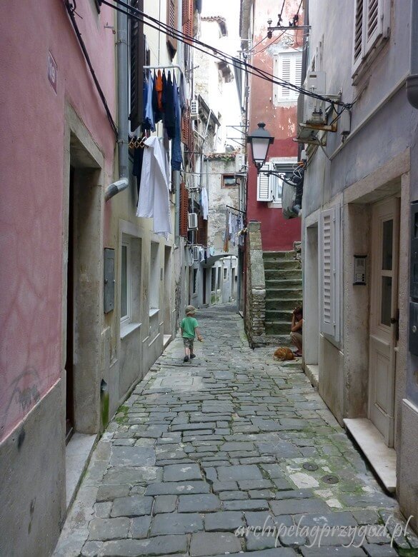 Spacer wąskimi uliczkami w najpiękniejszym miasteczku na słoweńskim wybrzeżu. Nad głowami wiszące suszące się pranie. 
